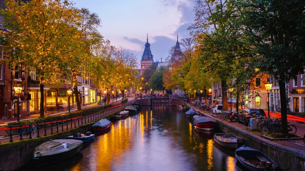 As twilight descends over Amsterdam, the canals reflect the golden hues of autumn leaves and warm street lights.